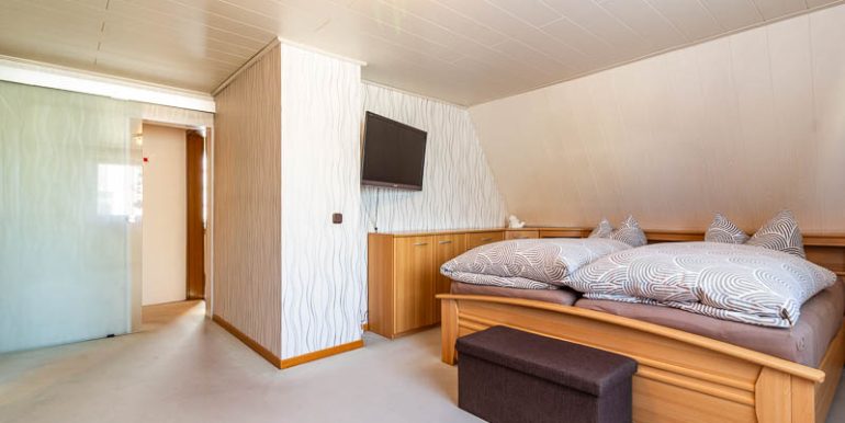 Das großzügige Schlafzimmer mit großem Fenster, viel Tageslicht und harmonischem Teppichboden.