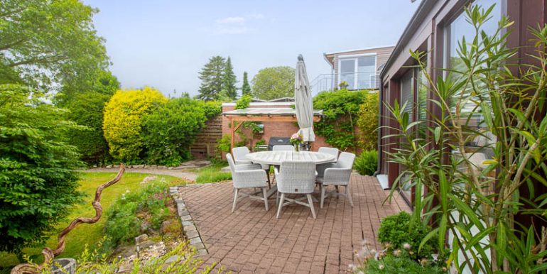 Die stilvolle Terrasse am Wintergarten bietet Raum für gesellige Abende und entspannte Stunden im Garten.