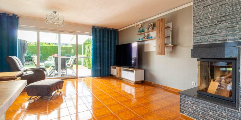 Wohnzimmer mit bodentiefen Fenstern, Blick in den Garten und Zugang zur überdachten Terrasse – ein Wohnbereich mit Weitblick.