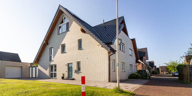Repräsentative Doppelhaushälfte in moderner Klinkeroptik mit großer Einfahrt, Garage und gepflegtem Vorgarten – ein Zuhause mit Charakter.