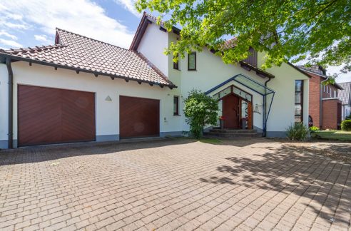 Großzügige Einfahrt, zwei Garagen und ein einladender Hauseingang – dieses Zuhause überzeugt schon beim ersten Eindruck.