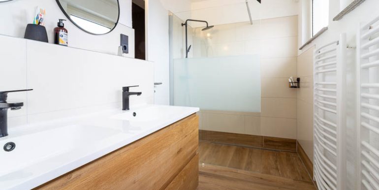 Modern, hell und komplett kernsaniert – das Badezimmer überzeugt mit begehbarer Dusche, Doppelwaschbecken und hochwertiger Ausstattung.