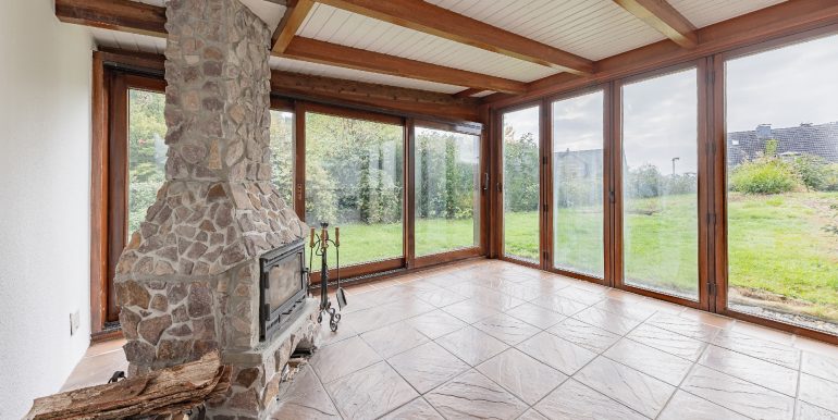 Wintergarten mit grüner Aussicht und Kamin