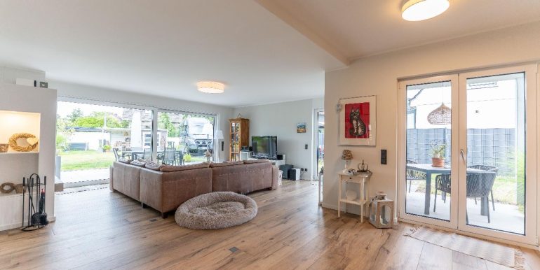 Lichtdurchfluteter Wohnbereich mit Kamin und diversen Zugängen zum liebevoll ang